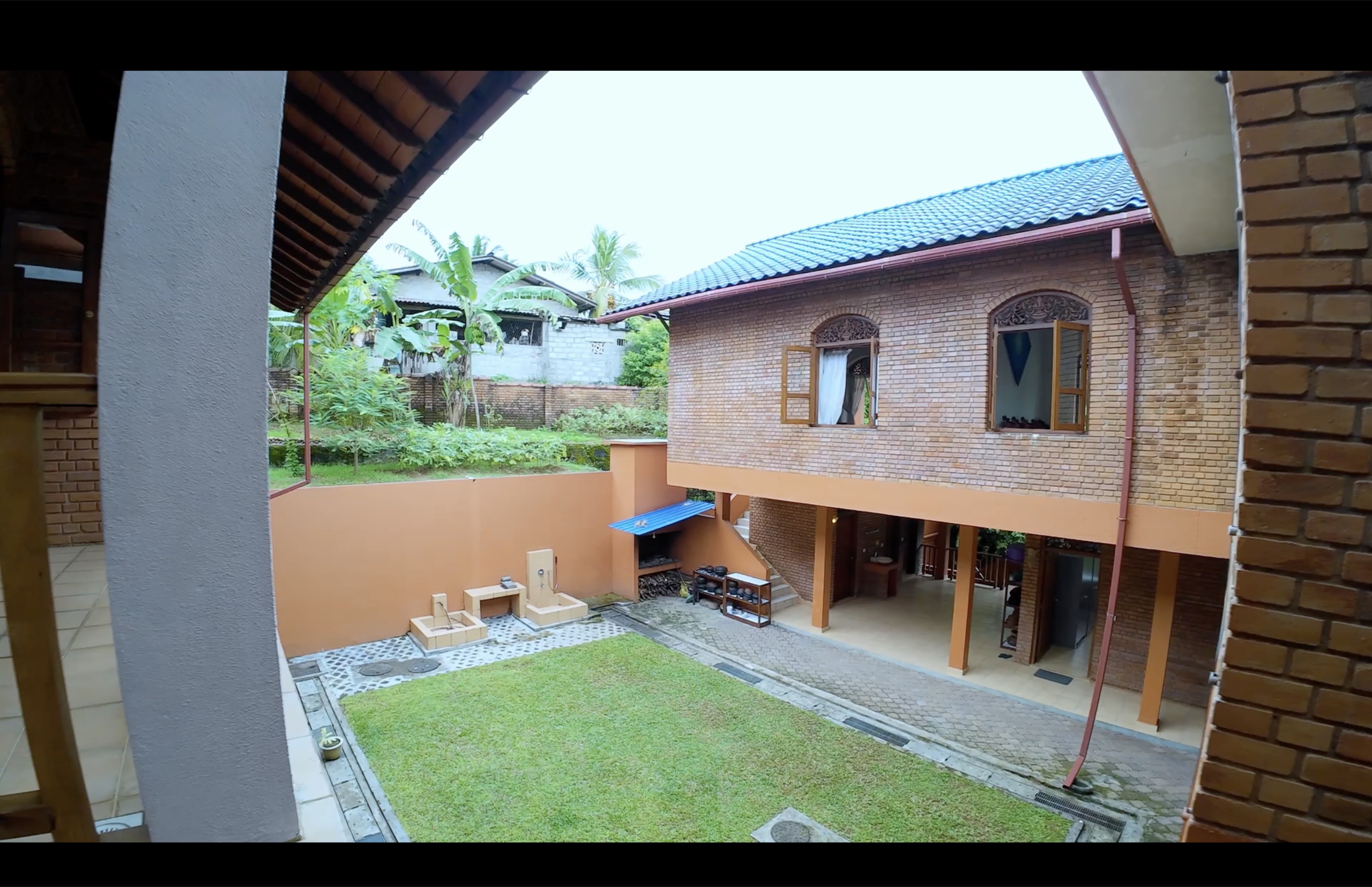 Interior garden atrium with tropical planting beneath the roof lantern at Oasis Estate